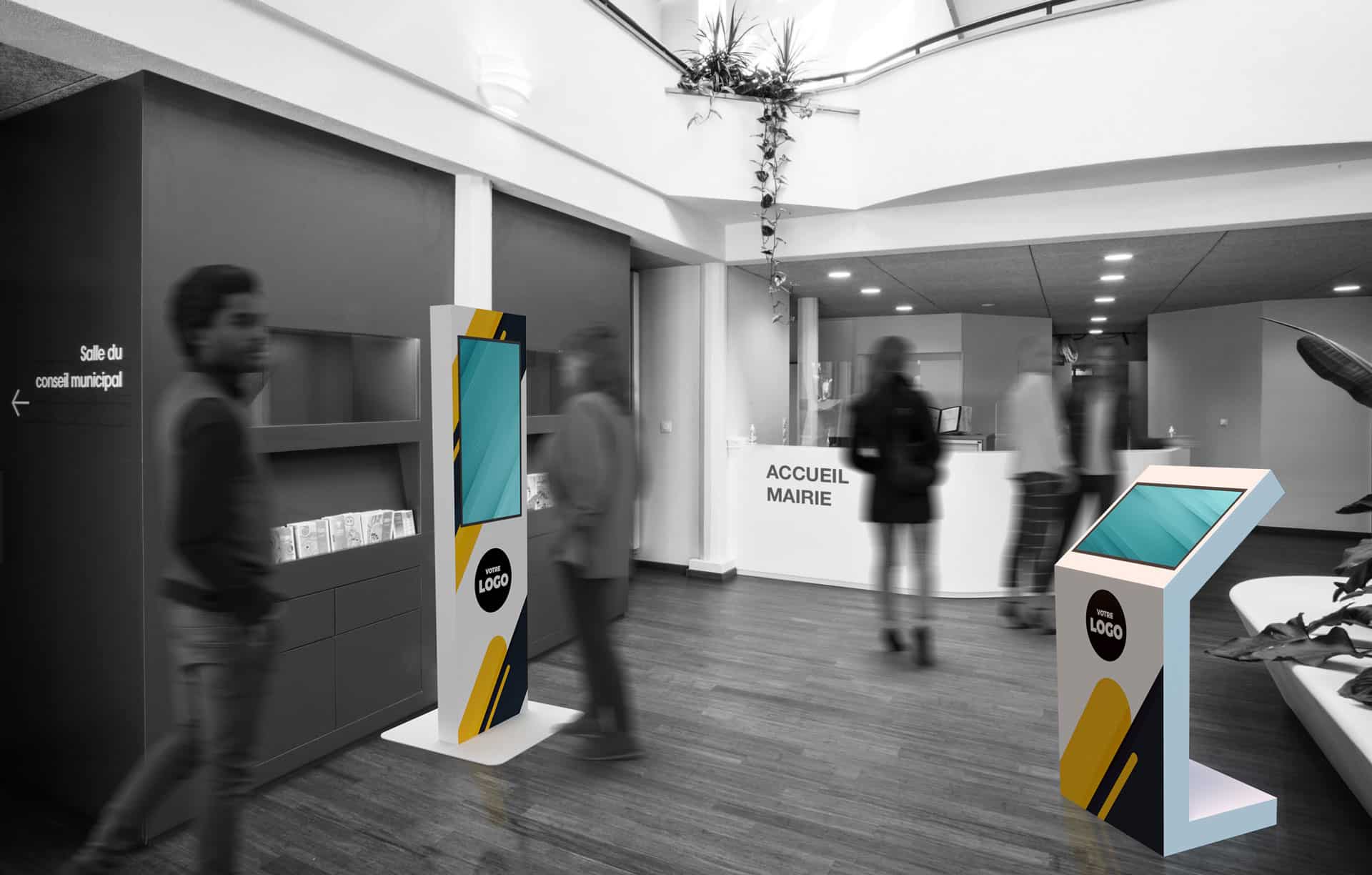 Les visiteurs traversent un hall moderne doté de bornes numériques et d'un comptoir d'accueil portant l'inscription « ACCUEIL MAIRIE ». L'ambiance est majoritairement en noir et blanc, à l'exception des bornes colorées.
