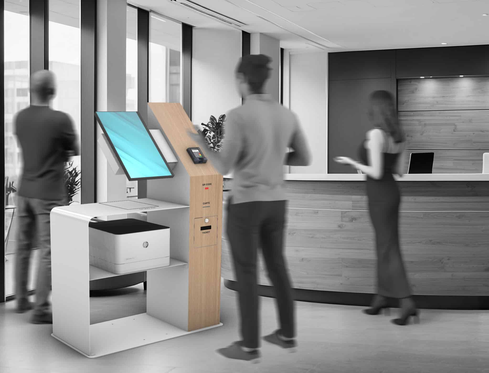 Trois personnes se trouvent dans le hall d'un bureau moderne ; l'une d'entre elles utilise une borne libre-service dotée d'un écran tactile et d'une imprimante, tandis que deux autres se tiennent près de grandes fenêtres et d'un bureau d'accueil.